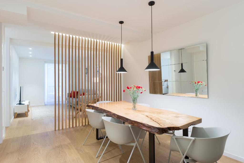 圣塞瓦斯蒂安Fermin Suite - Iberorent Apartments的一间带木桌和椅子的用餐室