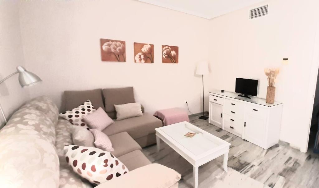 塞维利亚Apartamento Realengo Sevilla的客厅配有沙发和桌子