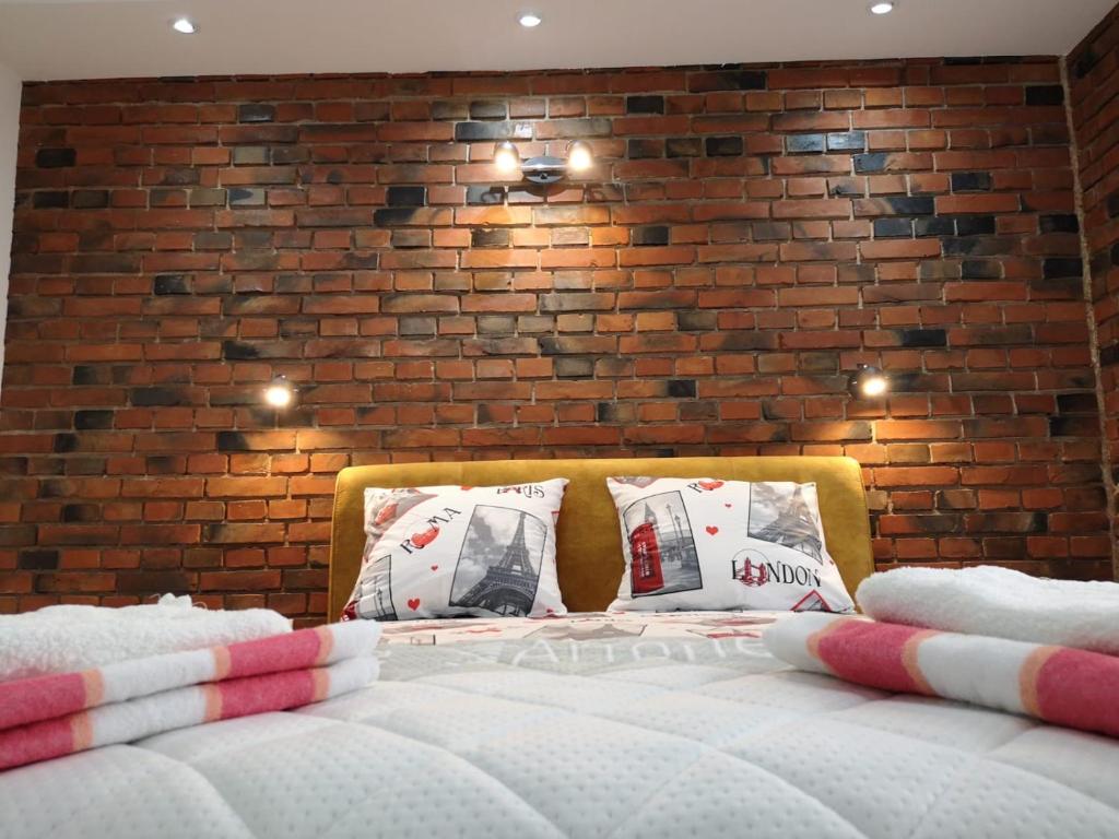 莱斯科瓦茨Nikolic Apartment 2的砖墙房间的一个床位