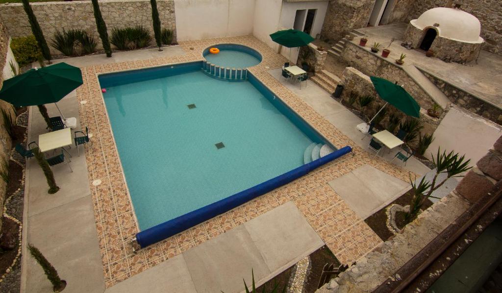克雷塔罗HOTEL ECOTURISTICO LA SALITRERA的享有带遮阳伞的游泳池的顶部景致