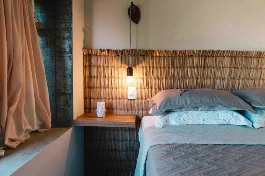 加罗帕巴Marafunda Hospedaria, Praia da Gamboa的一间卧室配有一张带木制床头板的床