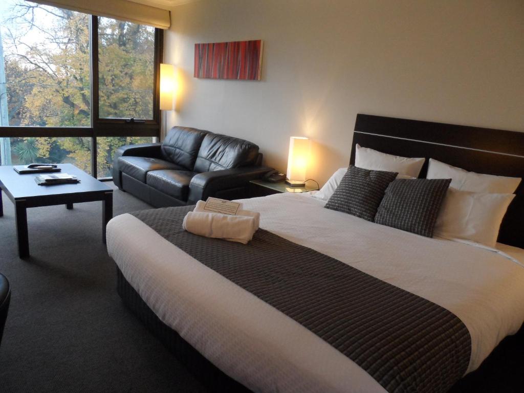 朗塞斯顿科摩多里根酒店的一间卧室配有一张大床和一张沙发