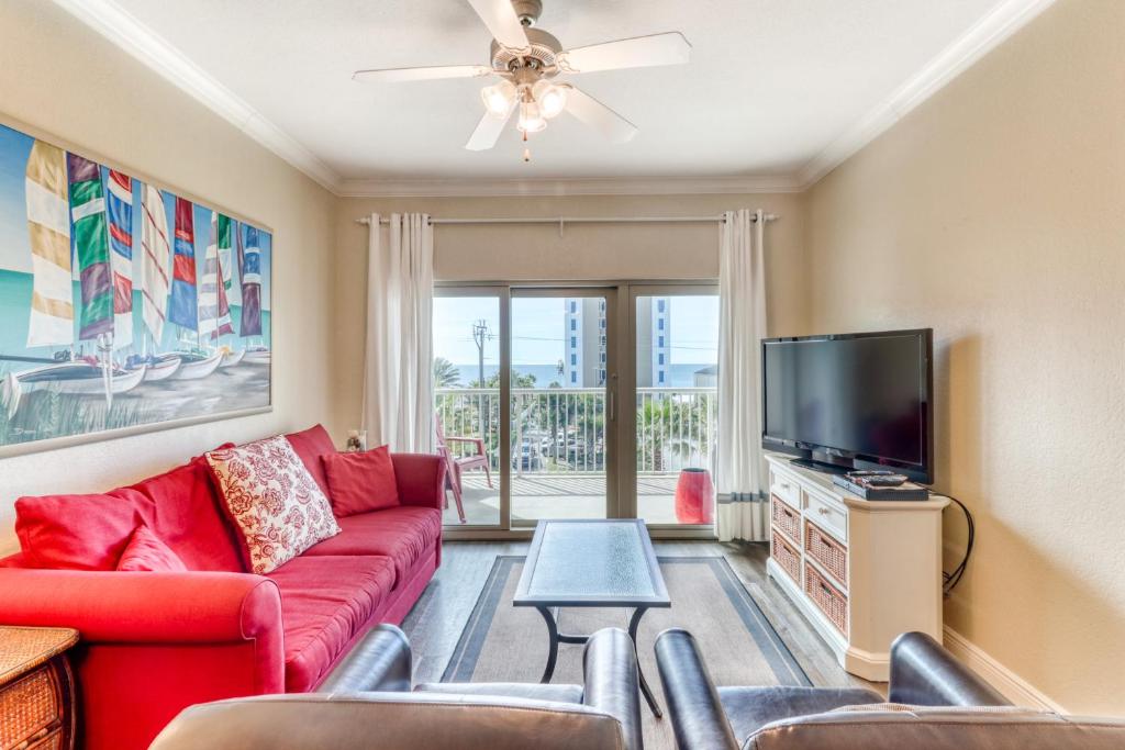 格尔夫海岸Crystal Tower Condominiums的客厅配有红色沙发和平面电视
