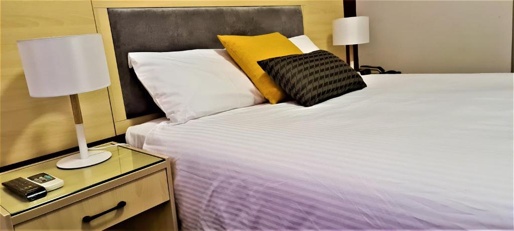 墨尔本布伦瑞克大厦酒店的一间卧室配有一张大床,设有床头柜和台灯
