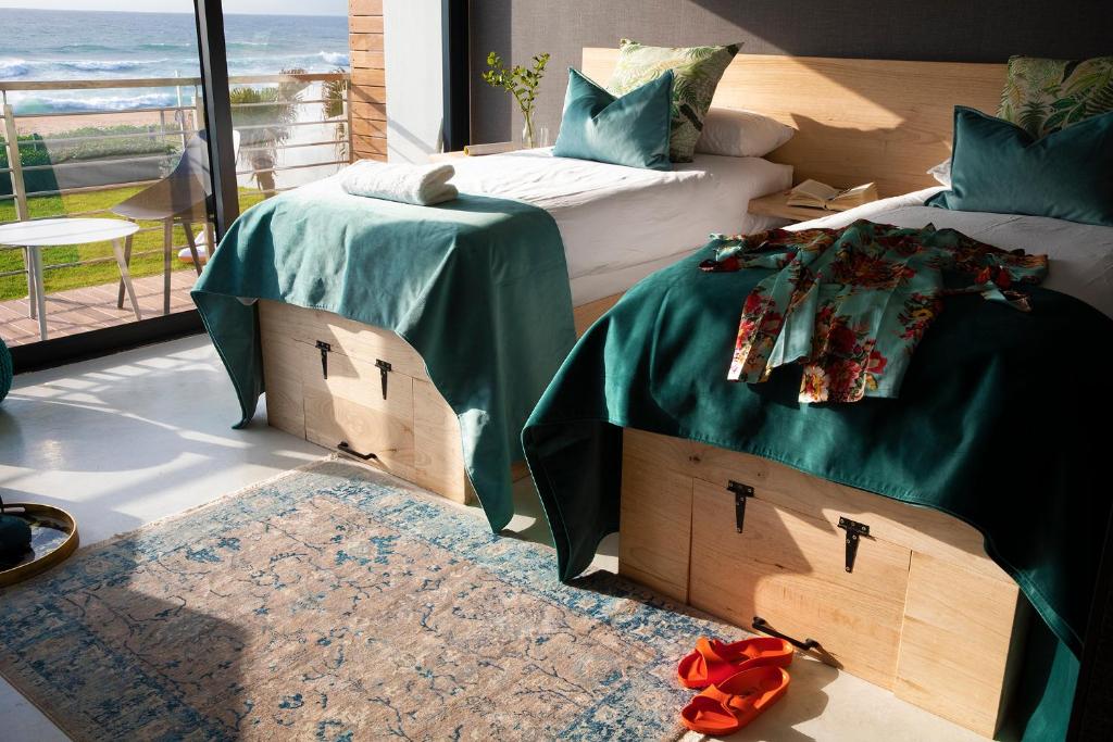 德班Northstar-Hotel的一间卧室设有两张带绿床单的床和窗户。