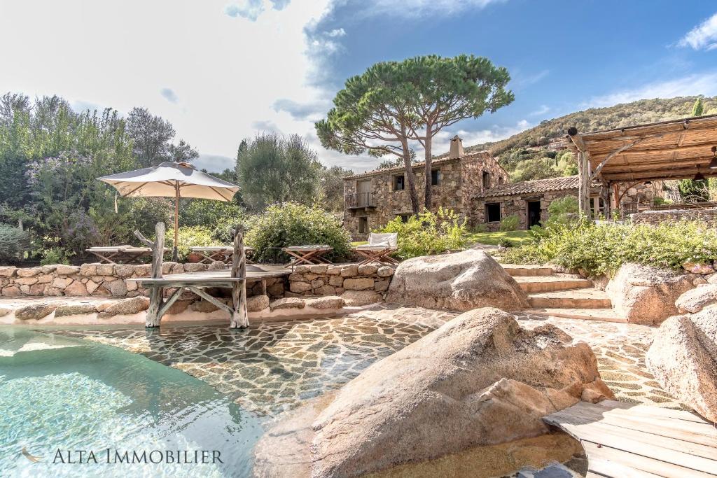 维琪奥港Villa Serenita Pallombaggia的一个带长凳和遮阳伞的游泳池