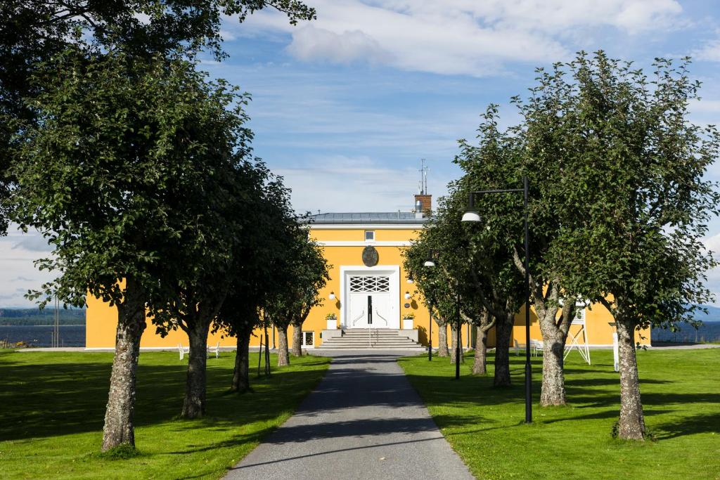 莫斯Hotell Jeløy Radio的前面有树木的黄色建筑