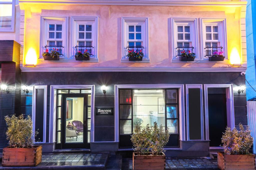 伊斯坦布尔Meroddi La Porta Hotel的前面有盆栽植物的粉红色房子