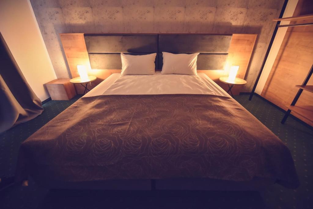 蒂米什瓦拉Villa Rosa的一间卧室配有一张大床和两盏灯