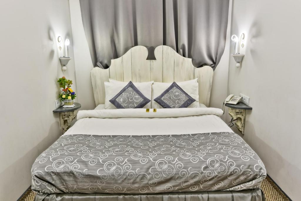 鄂木斯克朱可夫宾馆的卧室配有带蓝色枕头的大型白色床
