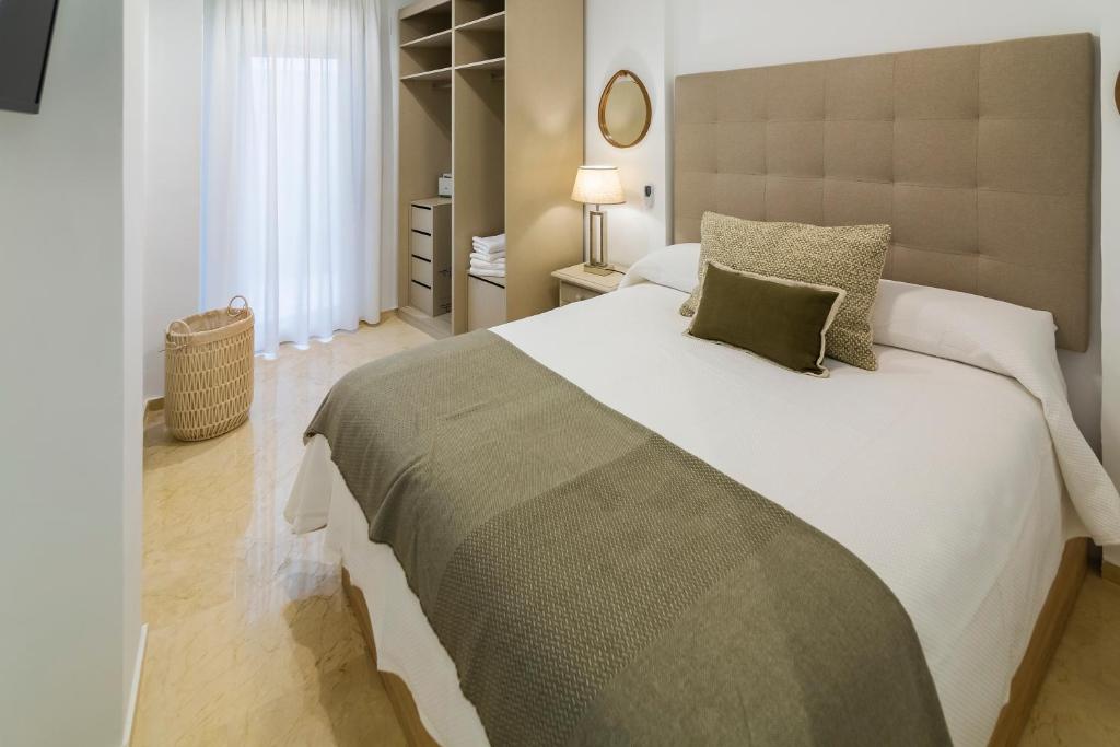 科尔多瓦Apartamento Emilo Luque Cinco的卧室配有带绿色枕头的大型白色床