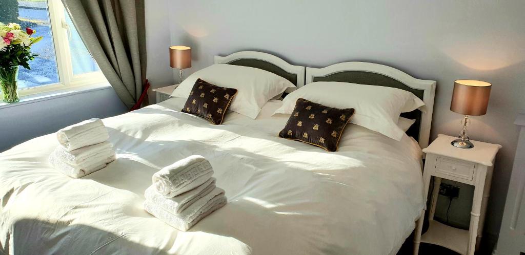 斯托昂泽沃尔德Maugersbury Park Suite的一间卧室配有两张带白色床单和枕头的床。