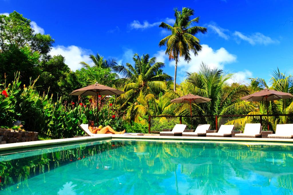 费尔南多 - 迪诺罗尼亚瓦尔杜旅馆的一个带椅子和遮阳伞的游泳池