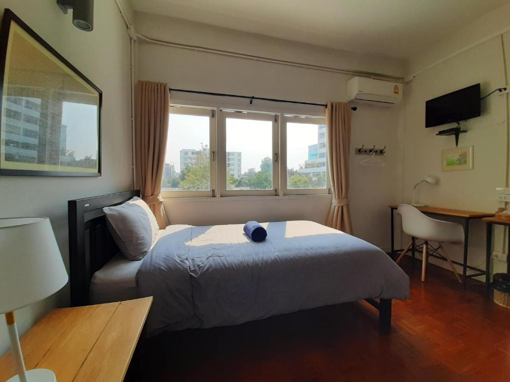 曼谷Pingplalee Female House的卧室配有床、椅子和窗户。
