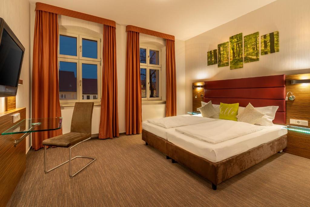 吕本瑙Hotel und Restaurant Zum Deutschen Hause的酒店客房,配有床和电视