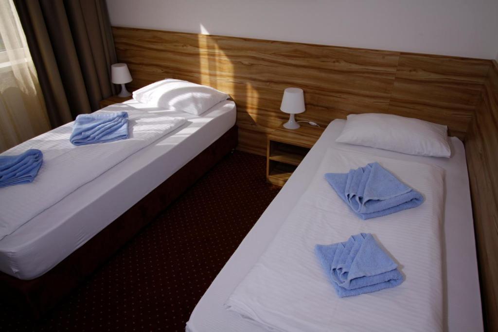 布拉迪斯拉发布拉迪斯拉发加尼飞行员酒店的两张位于酒店客房的床,上面有蓝色的毛巾