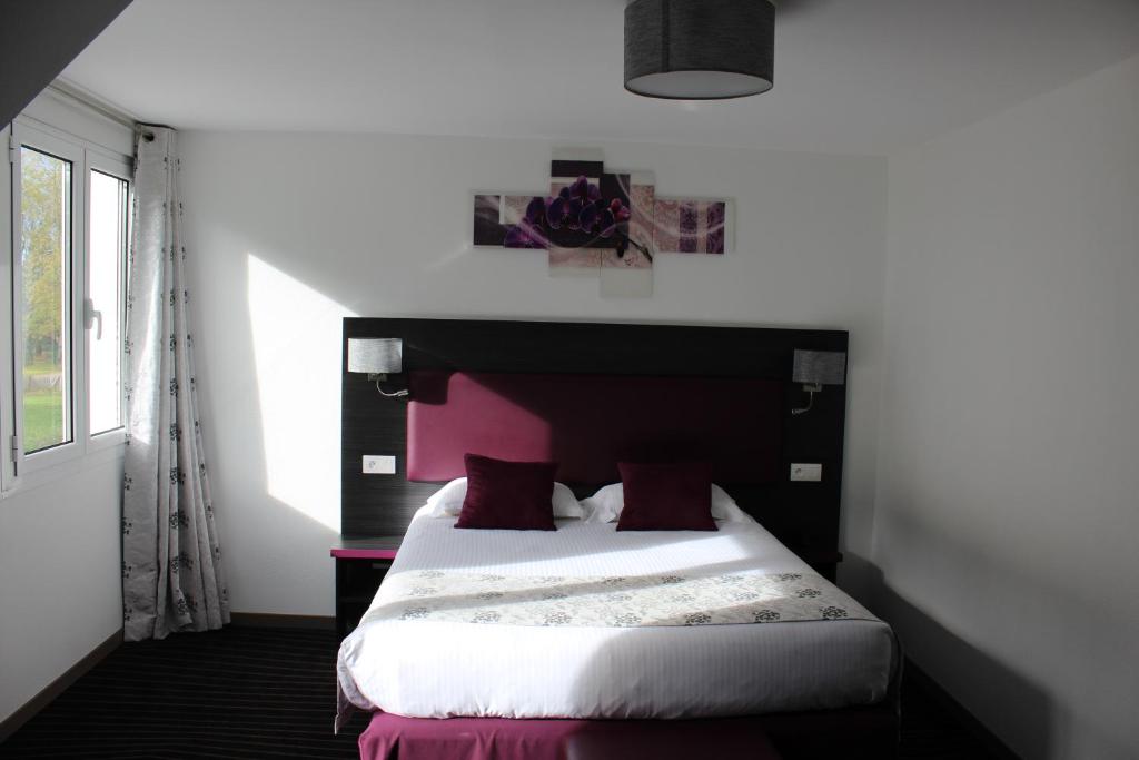 博韦The Originals City Hôtel, Aéroport Beauvais (ex: Inter-Hotel)的一间卧室配有一张带粉红色床头板的床
