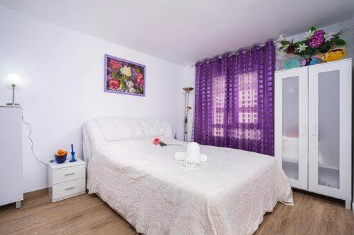 德尼亚Guest House Lana Denia的卧室配有白色的床和紫色窗帘
