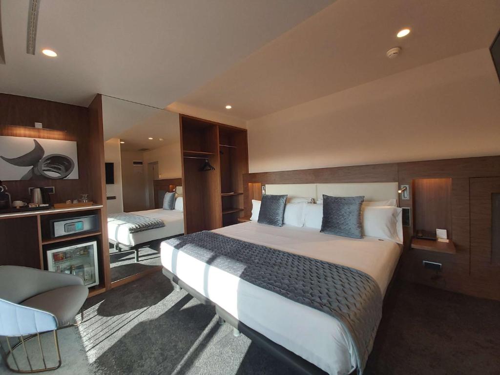 巴塞罗那旦汀贝斯特韦斯特高级酒店的酒店客房带一张大床和一把椅子
