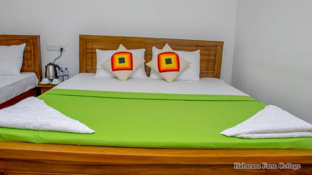 AvudangawaHabarana Farm Cottage的一间卧室配有一张带四个枕头的大型绿床