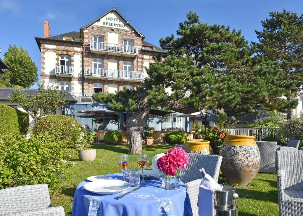 维莱尔维尔贝尔维尤酒店的一张带酒杯和鲜花的蓝色桌子