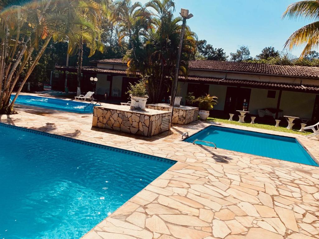 博西坎加Boiçucanga Completo à Beira Mar的棕榈树屋旁的游泳池