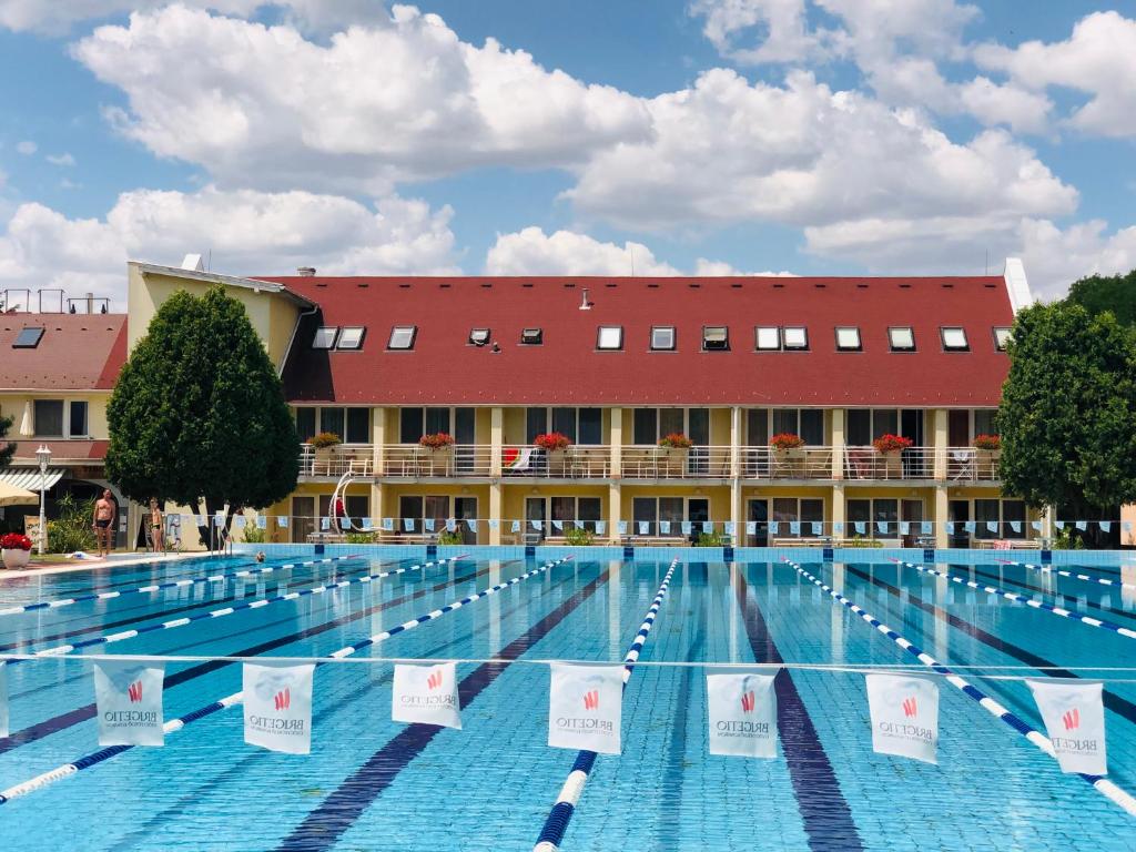 科马罗姆哈特维泽公寓酒店的一座大型游泳池,其建筑背景为: