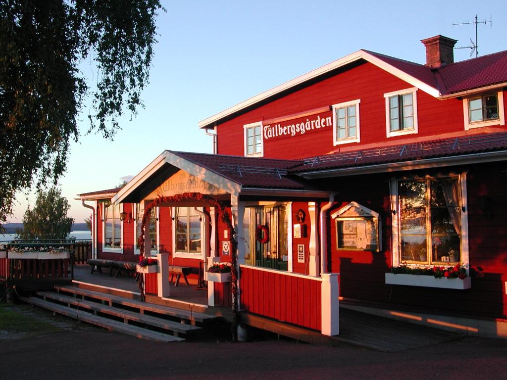 塔尔伯格托尔堡斯农场酒店的一座红色的建筑,前面有一间餐厅