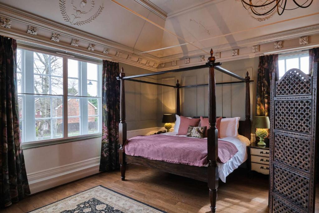 布罗姆利公牛头酒店的一间卧室设有四柱床和窗户。