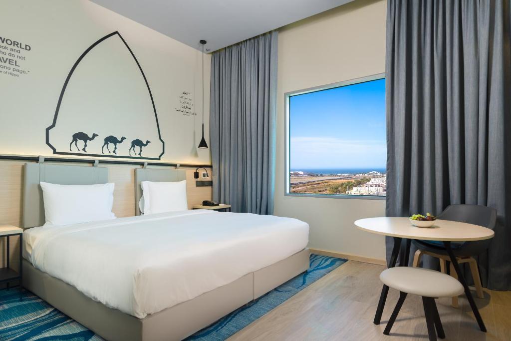 马斯喀特Swiss-Belinn Airport Muscat Oman的酒店客房设有床和窗户。