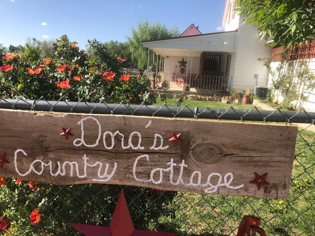 埃斯卡兰特Dora's Country Cottage的院子前的栅栏上的一个标志