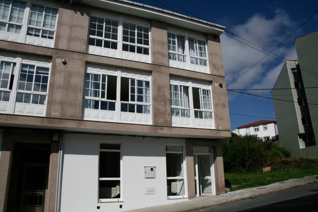 帕拉斯德丽Lar do Peregrino的街道上设有白色窗户的建筑