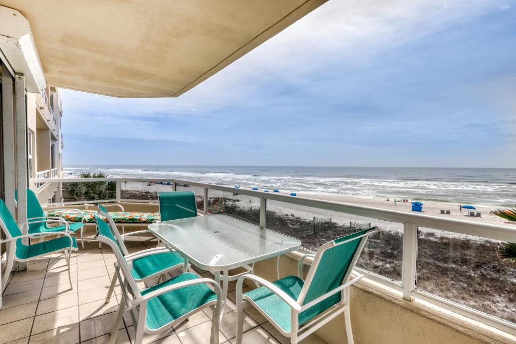 奥兰治比奇Enclave 304的一个带桌椅和海滩的阳台