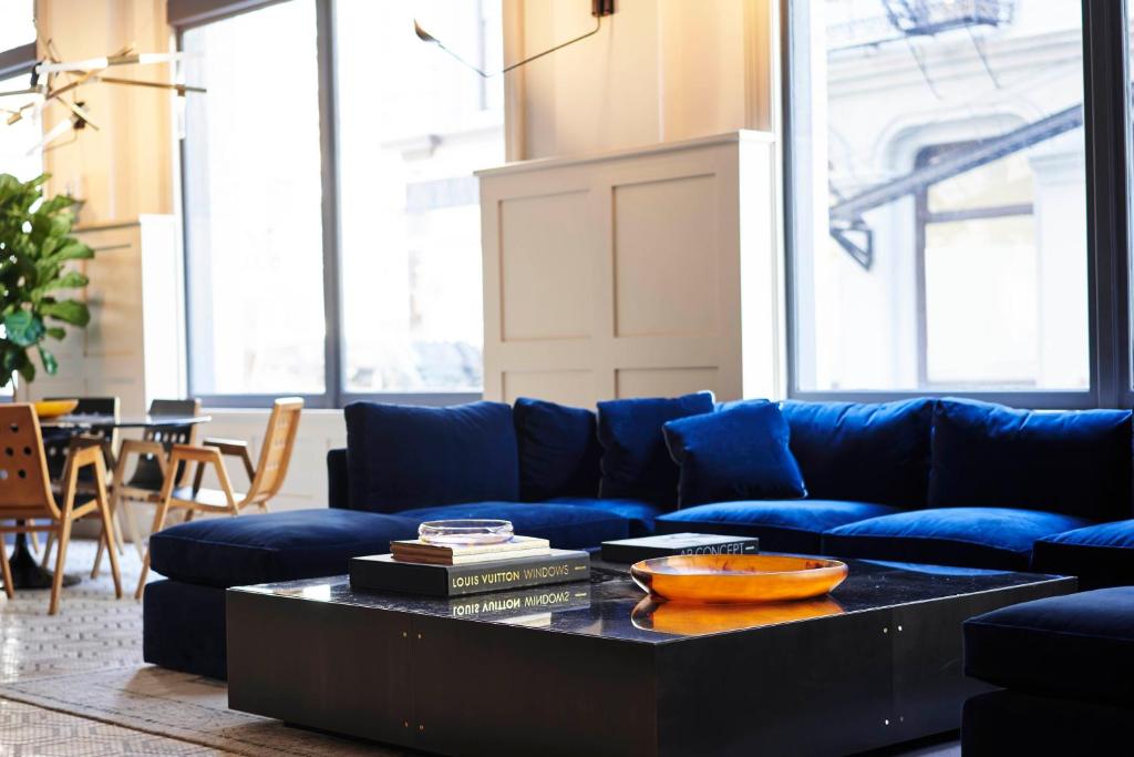 纽约Walker Hotel Tribeca的客厅配有蓝色的沙发和茶几