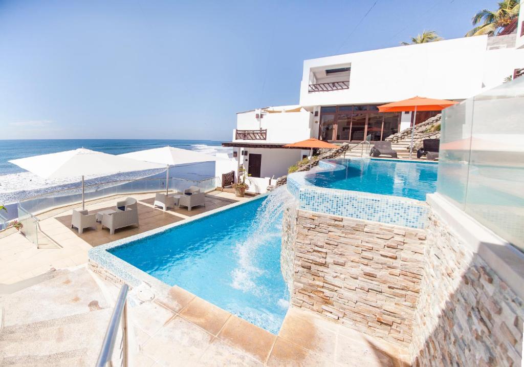 拉利伯塔德罗斯法拉龙斯酒店的享有游泳池的景色,位于一个以大海为背景的度假胜地