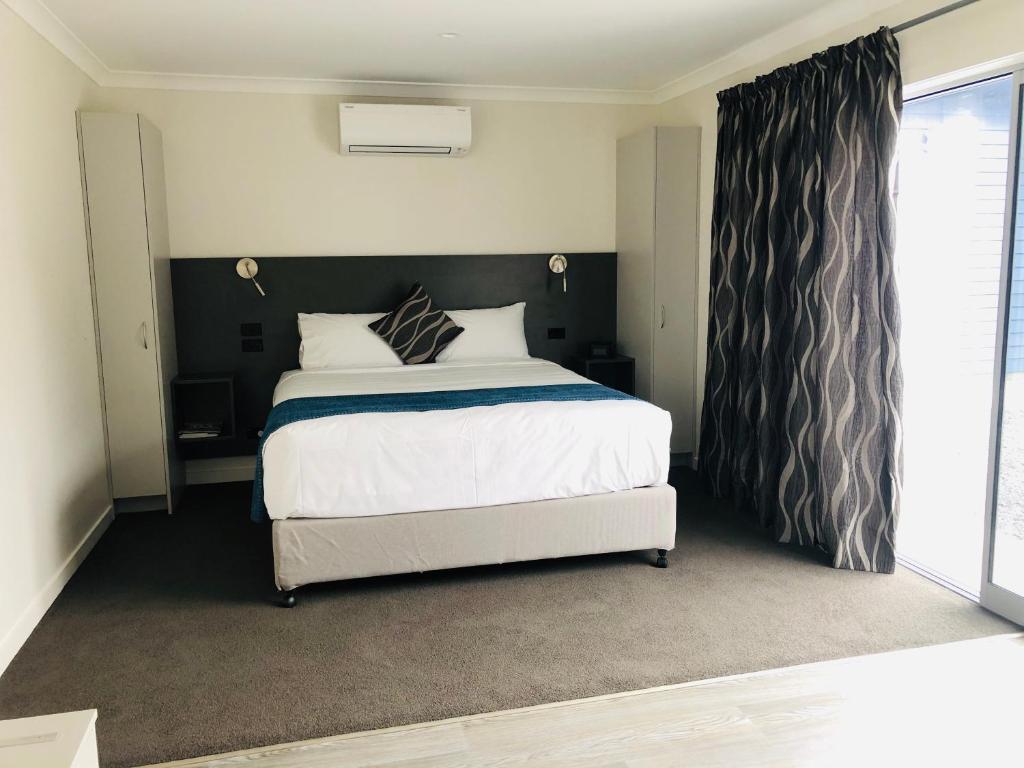  Waipukurau桑顿汽车旅馆的一间卧室设有一张大床和一个窗户。