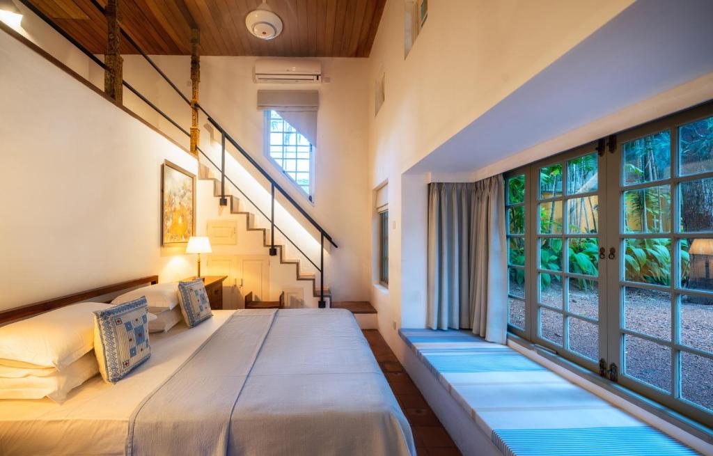 科伦坡De Saram House by Geoffrey Bawa的一间卧室设有两张床和大窗户