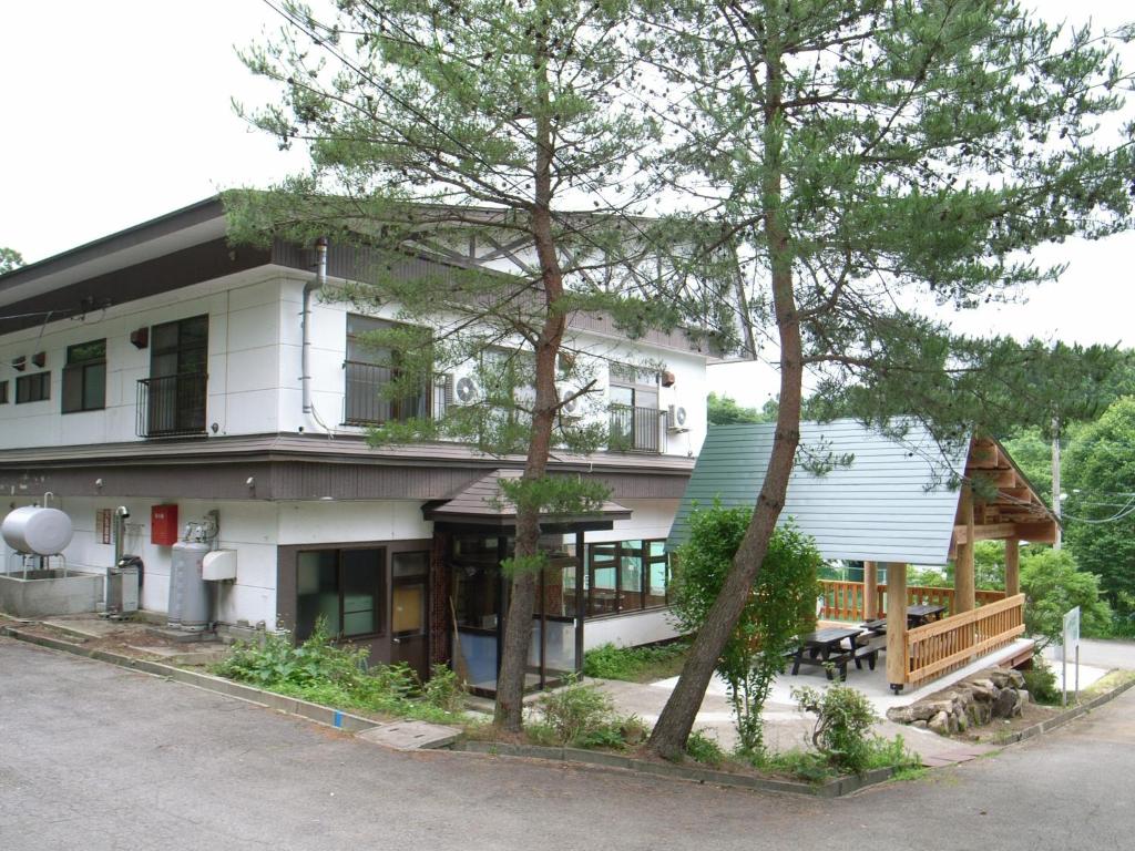 猪苗代町Cottage All Resort Service / Vacation STAY 8438的前面有树木的白色房子