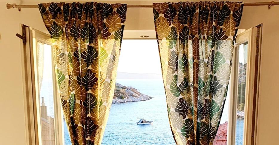 特里班Apartman Šime的窗户配有窗帘,享有海景