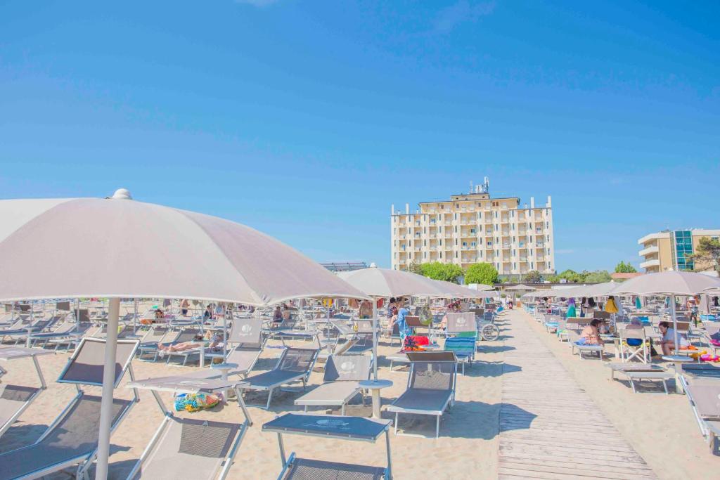 利多克拉西Hotel Adler的沙滩上的一把椅子和遮阳伞