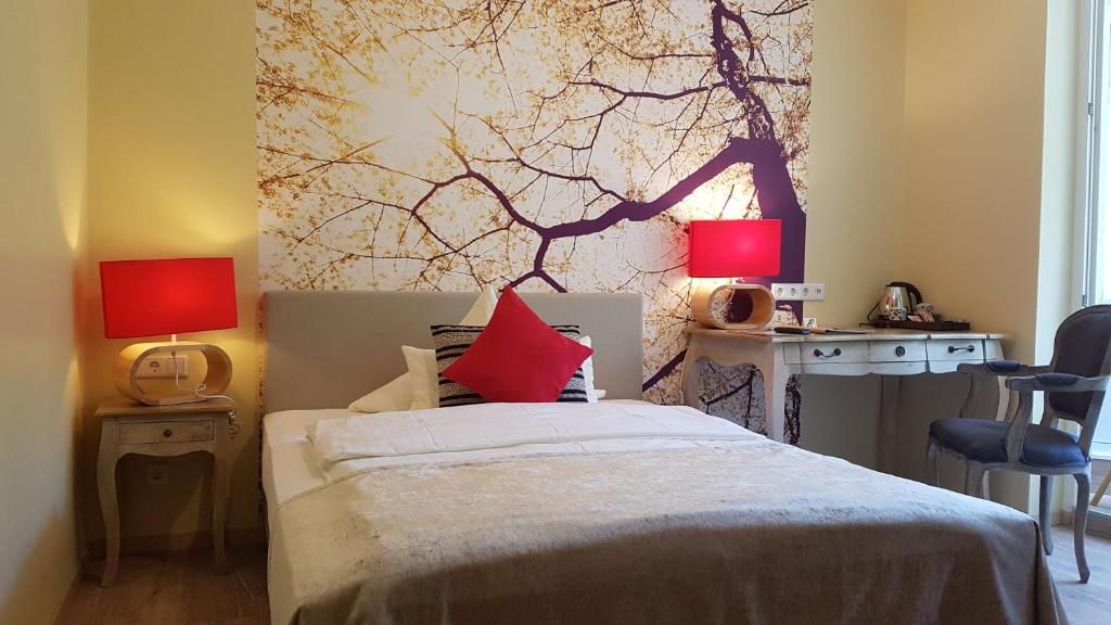 杜塞尔多夫翠园别墅酒店的一间卧室配有一张带两盏灯的床和一张书桌。
