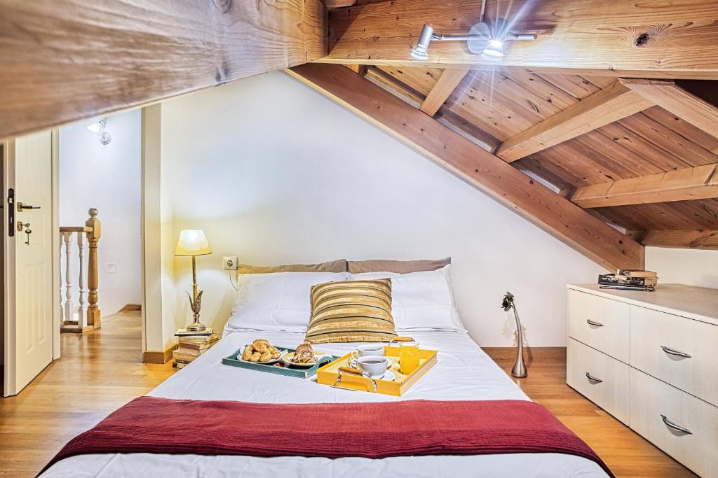 AnemómylosCASA MIRKA Corfu Petite Maisonette的一间卧室设有一张带木制天花板的大床。