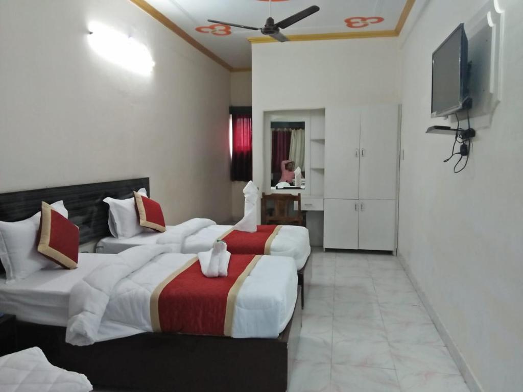 KushinagarHOTEL BUDDHA的酒店客房设有两张床和一台平面电视。