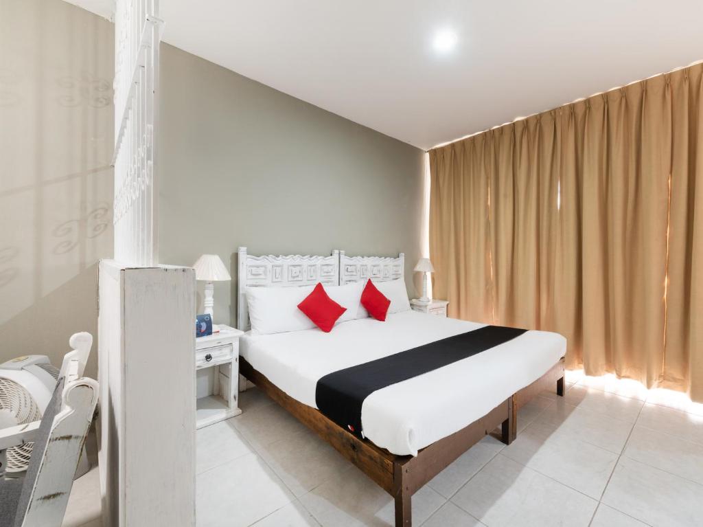 瓜达拉哈拉Suites Internacional的卧室配有带红色枕头的大型白色床