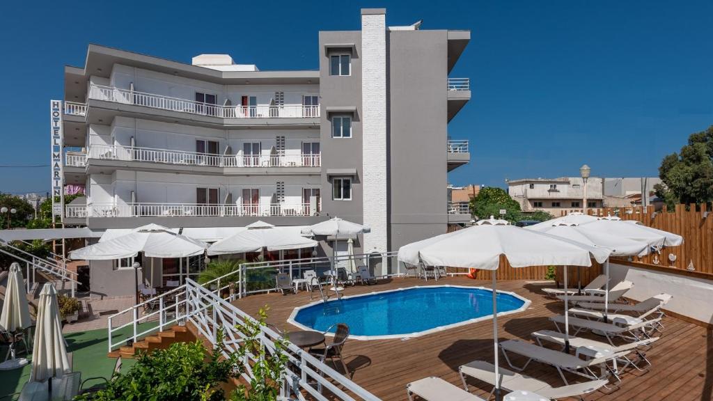 罗德镇Marine Congo Hotel的一座带游泳池和白色遮阳伞的酒店