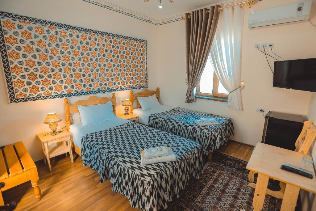 布哈拉优思明酒店的一间酒店客房,设有两张床和电视