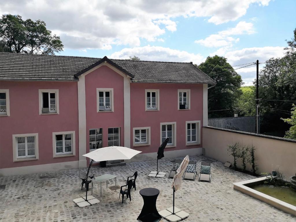利勒阿当Les 7 Sources的粉红色的房子前面设有桌椅