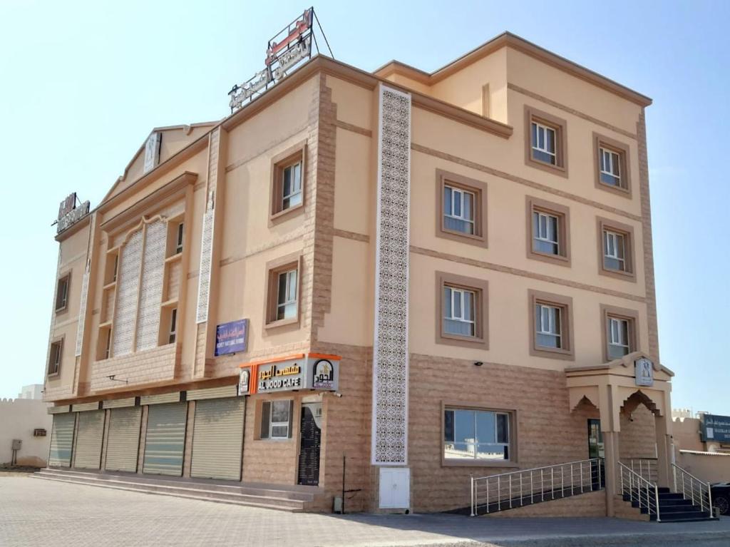 ḨilfAL JOOD HOTEL APARTMENT的街道前方的大建筑
