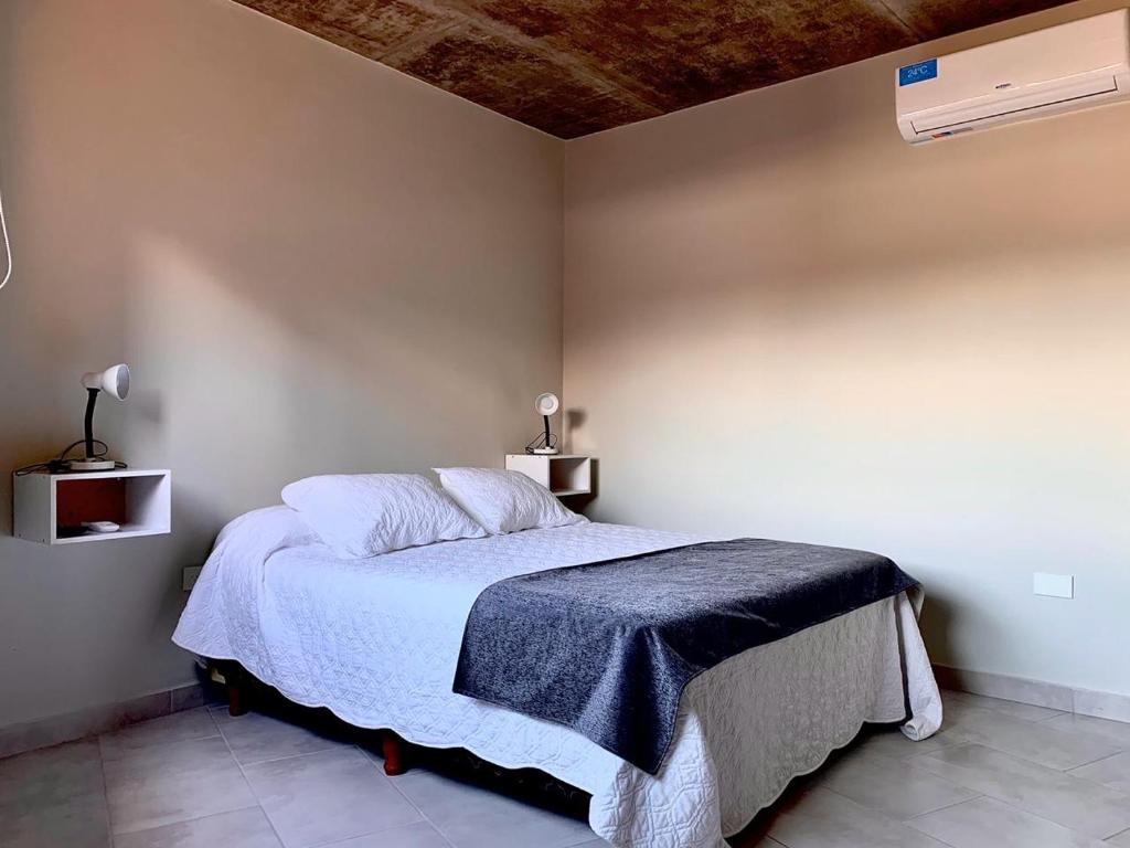 圣萨尔瓦多德朱CERROS del NORTE II Departamentos的一间卧室配有一张带蓝色毯子的床