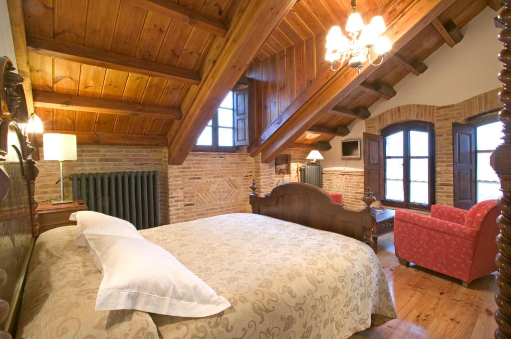 卢耶哥索摩查卡米诺旅馆的一间带一张大床的卧室,位于一个拥有木制天花板的房间